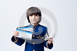 The little boy learns the profession of a pilot. He plays with toy airplane in the pilot`s uniform.
