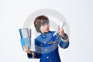 The little boy learns the profession of a pilot. He plays with toy airplane in the pilot`s uniform.