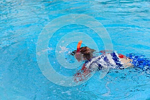 Little boy learns swimming alone in the pool