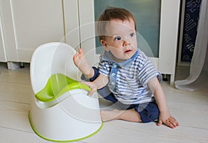 A little boy learns to go potty. Accustom the child to the potty