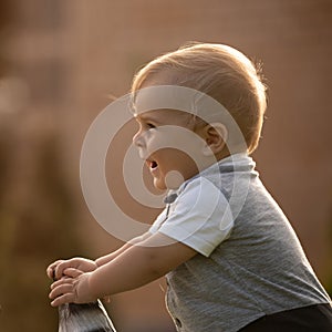 A little boy learns to walk with the help of a wheelchair.