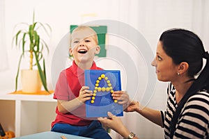 Little boy during lesson with his speech therapist.