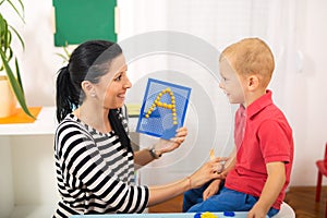 Little boy during lesson with his speech therapist.