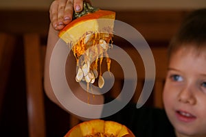 Little Boy Lifts Top Off of a Pumpkin He is Excited to Carve