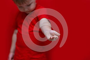 Little boy look down and pulls his hand to camera, kid wanted help for him