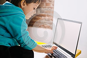 Little boy looking in amazement at a laptop.