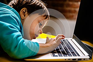 Little boy looking in amazement at a laptop