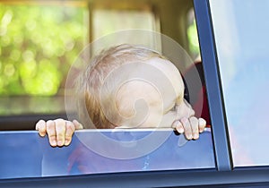 A little boy looking out of the car