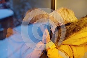 Little boy looking out of the window of train during travel on cogwheel railway/rack railway in Alps mountains