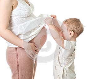 Little boy looking on pregnant mother`s belly