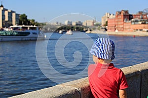 Little boy looking at the quay in city