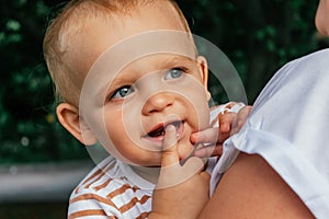 Little boy looks over his mother's shoulder.