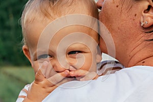 Little boy looks over his mother& x27;s shoulder.