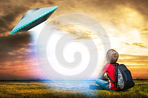 The little boy looks up at an unidentified flying object which appeared in the sky.