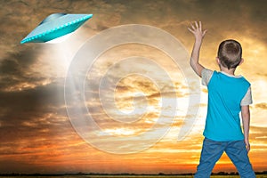 The little boy looks up at an unidentified flying object which appeared in the sky.