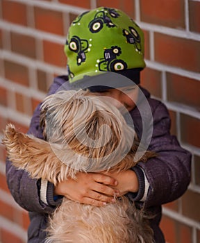 Little boy lovingly hugging his dog. Focus on the dog.