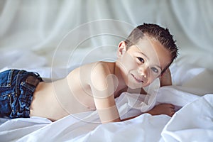 Little boy lying on bed