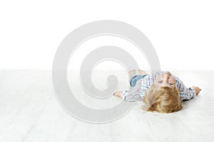 Little boy lying down on floor, looking at camera