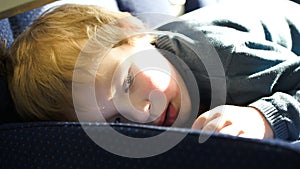 Little boy lying on the seat in the bus, car ot