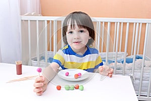 Little boy made lollipops of playdough and toothpicks