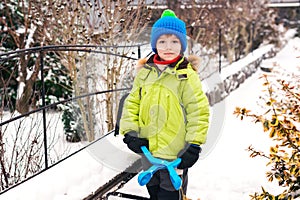 Little boy makes snowballs with snowball maker. Happy child playing with snow. Cold winter weather. Winter activities for kids