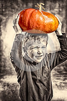 Little boy making a face with heavy orange pumpkin hat