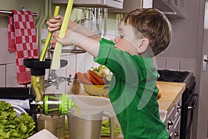 Little boy making green juice photo