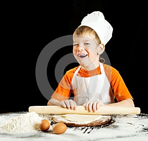 Little boy making pizza or pasta dough.