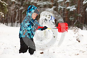 Little boy making snowman