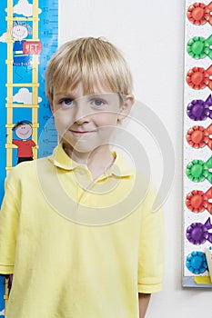 Little Boy Measuring Height In Classroom