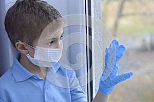 Little boy in a medical mask and protective gloves.