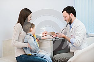 Little boy medical visit - doctor measuring blood pressure of a child