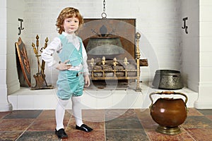 Little boy in medieval costume stands near