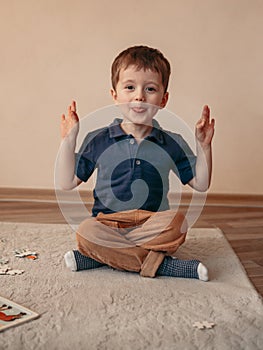 Little boy is meditating in the lotus position and smyling. yoga for young children