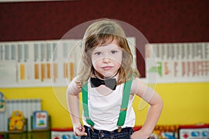 little boy medium plan. The boy is dressed in a bow tie. the child has long hair and an emotional facial expression. The