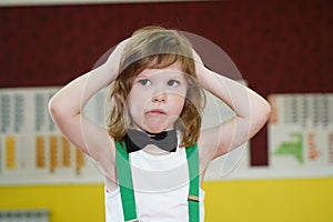 little boy medium plan. The boy is dressed in a bow tie. the child has long hair and an emotional facial expression. The