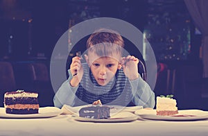 Little boy mesmerised by an assortment of cakes