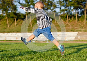 Little boy midair kicking a ball