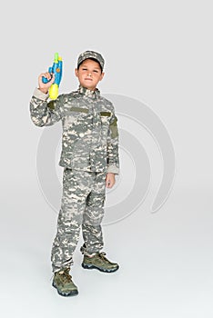 little boy in military uniform holding toy water gun