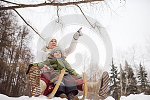 Little boy and mother/grandmother/nanny sliding in the Park