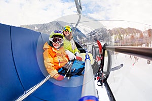 Little boy and mother on ski lift chair