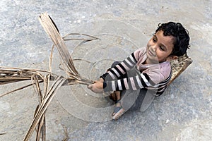 A little boy in a multicolor-shirt plays of his house on a summer day. A Kid Children Playing in the outdoors