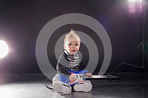 Little boy musician playing rock music on the guitar