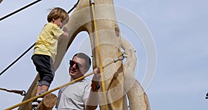 Little boy needs father`s help playground