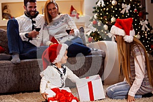 Little boy open Christmas gift-box with family