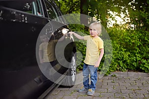 Little boy opening door of the car`s