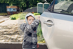 Little boy opening door of the car's. Family travels with kids