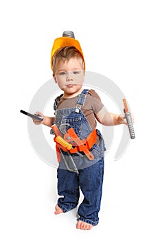 Little boy in an orange helmet with tools and a mobile phone on