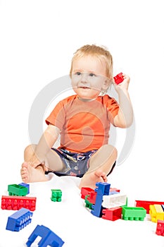 Little boy in an orange shirt is played Lego photo