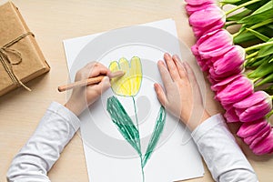 Little boy paints greeting card for Mom on Mother`s Day or 8 March